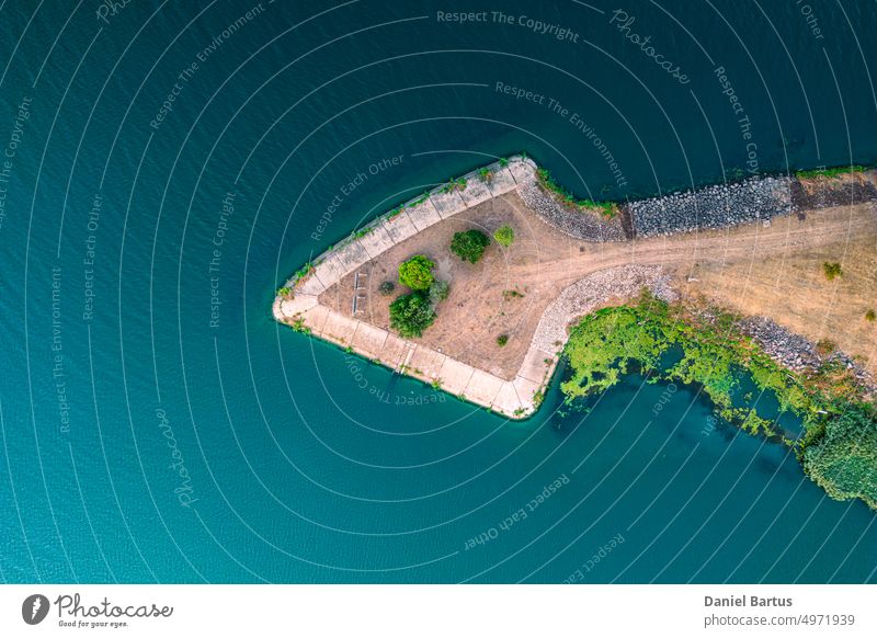 River branching. A shaft made of arrow-shaped stones. Separation of the river bed in front of the water dam. Arrow-shaped island. Aerial photo. sea beach coast