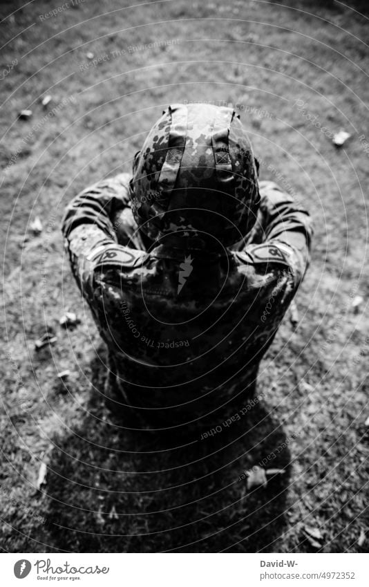 Soldier in Unifom of the German Armed Forces sits pensively on the ground Federal armed forces Think Meditative War military Fear uncertainty Uniform