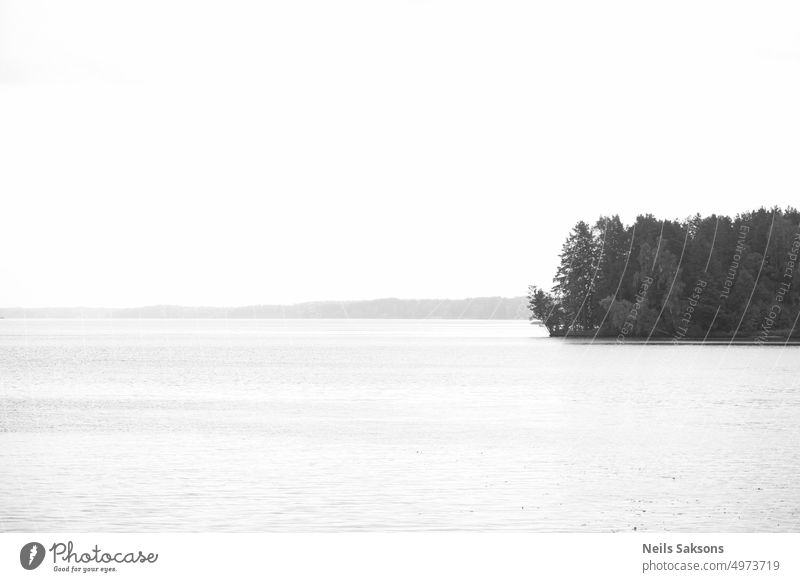 black and white landscape with lake and clear sky and small island covered with forest amazing autumn background beautiful blue calmness clean cloudy cold dawn