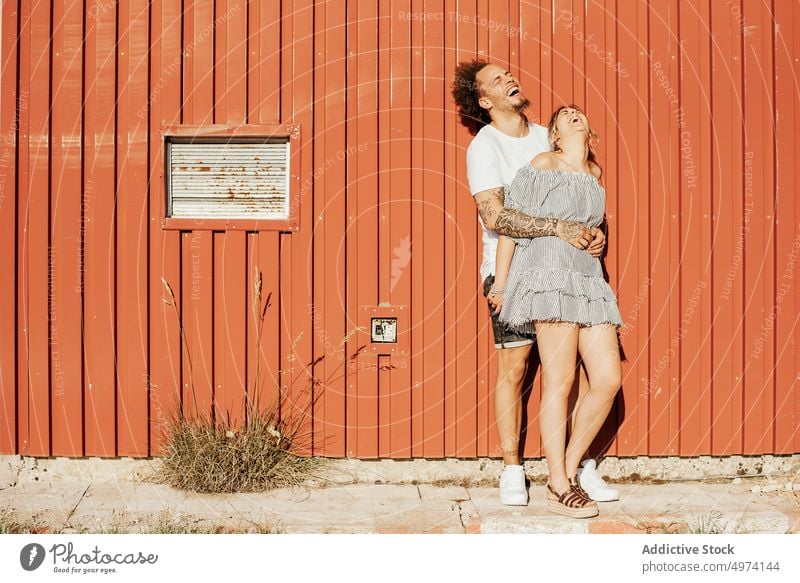 Happy couple embracing on street in sunny day embrace love together happy relationship affection romantic hug gentle hipster casual bonding urban pavement lover