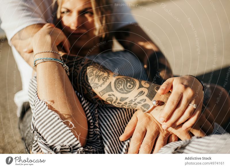 Young couple enjoying each other while sitting on road and embracing love hug hipster romantic sensual relationship happy street admire fondness girlfriend