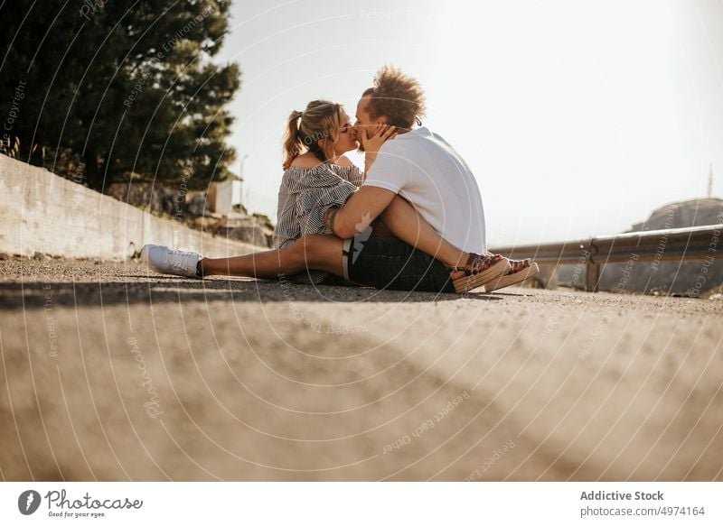 Happy young couple enjoying each other while sitting on road and embracing love hug hipster romantic sensual relationship happy street admire fondness