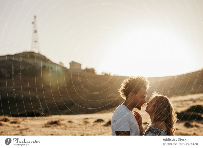 Trendy man looking at girlfriend while standing in countryside couple love romantic kiss hand gentle happy date relationship courtship lover boyfriend weekend