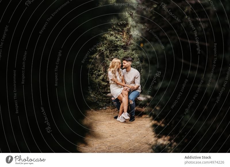 Happy couple sitting on bench and holding hands while having dat love date park attraction happy lover together romantic sentiment tender girlfriend boyfriend