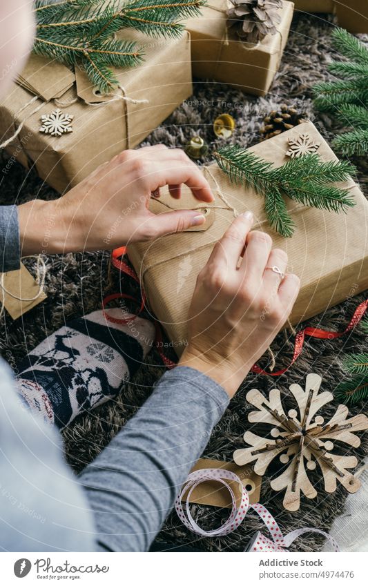 woman wrapping a christmas present indoors surprise box leisure xmas celebration merry gift gold bell hand handmade decoration decorated paper person gifts