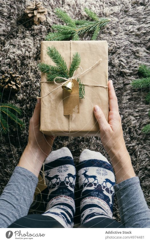 Closeup view of woman hands holding a handmade christmas present indoors surprise box leisure xmas wrapping celebration merry gift gold decoration decorated