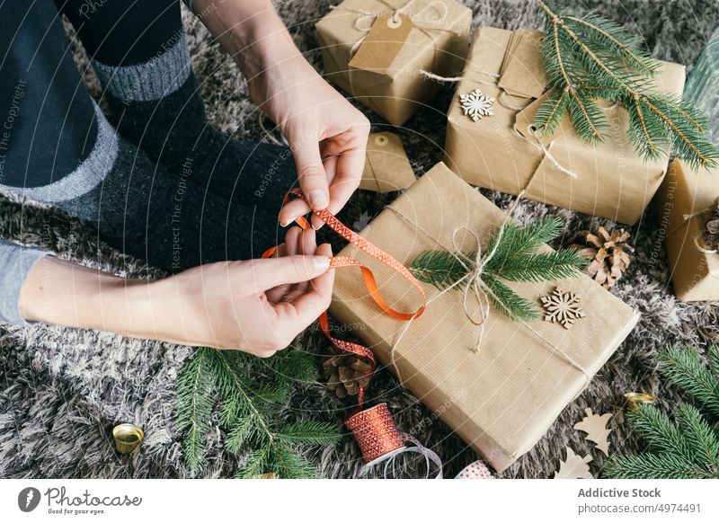 Closeup view of woman hands wrapping a handmade christmas present indoors surprise box leisure xmas celebration merry gift gold decoration decorated paper