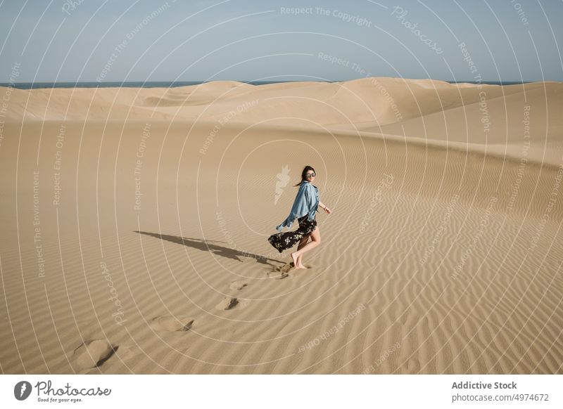 Woman standing on sand land and blue sky at sunset woman spain dune hand side desert freedom heaven evening young summer nature picturesque europe landscape