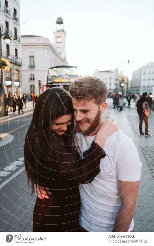 Romantic young couple in city streets hugging shyly madrid alcala beautiful woman happy attractive love vacation kiss female pretty winter christmas urban