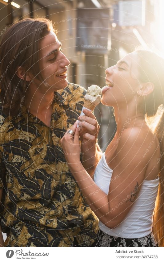 Joyful couple eating ice cream in street in love dessert valentine summer romantic having fun affection sunset happy relationship idyllic smile gentle cheerful