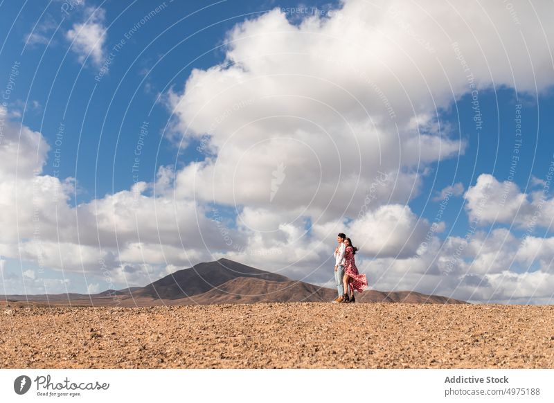 Loving couple embracing on dry terrain near volcanic mountains in Lanzarote embrace volcano romantic trip love together tender landscape relationship affection