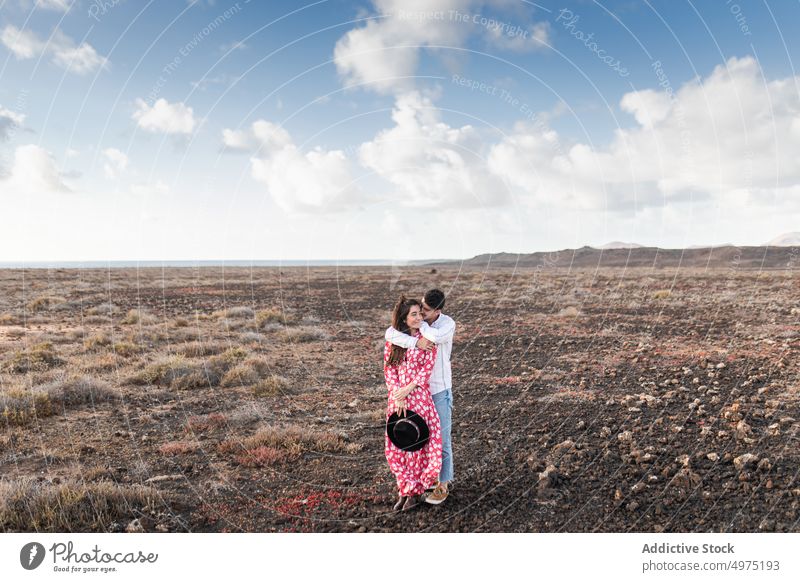 Young man kissing forehead of girlfriend in nature couple touch face romantic love field together affection date calm fondness tender relationship boyfriend