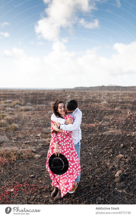 Young man kissing forehead of girlfriend with closed eyes in nature couple touch face romantic eyes closed love field together affection date calm fondness