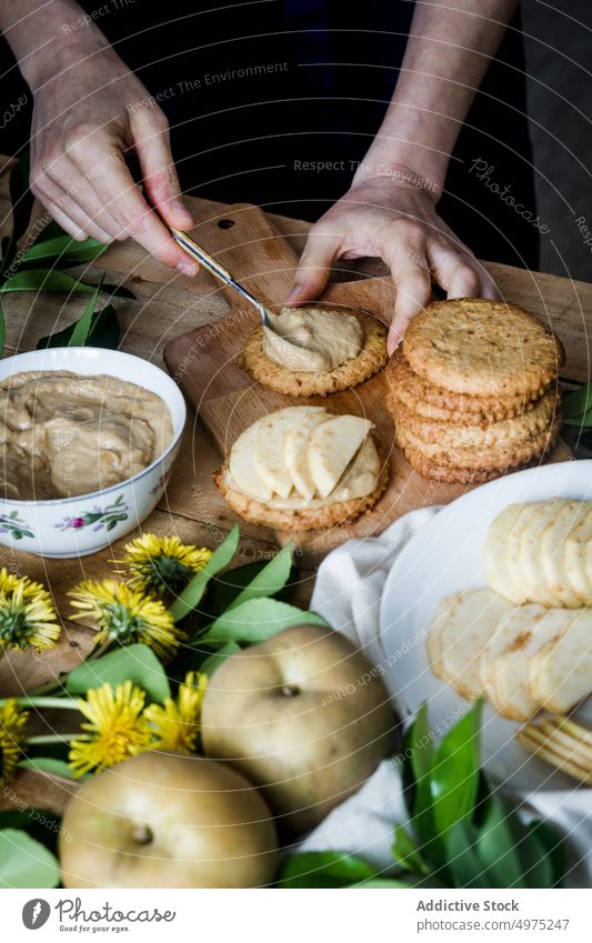 Crop person arranging apples on cookies dessert put tartlet table kitchen home food fresh meal delicious tasty yummy biscuit gourmet nutrition homemade fruit