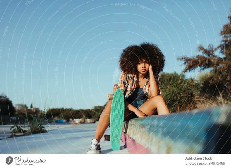 Tranquil African American woman with penny board on street summer skater cool millennial afro trendy tranquil hipster sunny female ethnic african american black