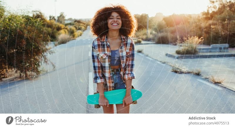 Cheerful ethnic woman with penny board road hipster summer skater afro sunset cheerful millennial female african american black trendy stand city chill urban