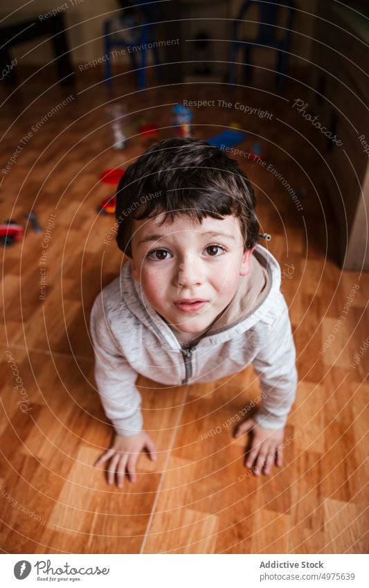 Angry boy looking at camera kid tantrum upset crying floor little child sad male childhood anger unhappy home free time house alone childcare copy space indoors