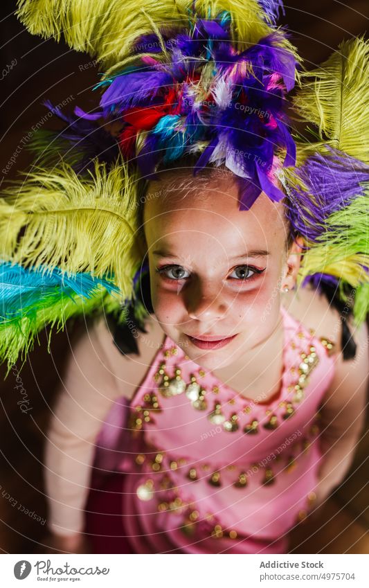 Little girl in carnival costume speak makeup headgear feather colorful kid child tradition glamour holiday fashion accessory style bright masquerade celebrate