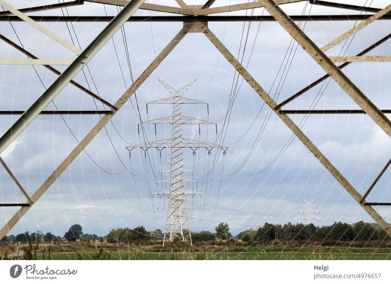 Power line - view through a power pole to other poles standing on pastures Electricity pylon power line power supply Energy Energy industry Power transmission