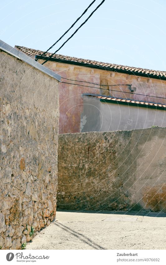 Walls of gardens and houses, power lines and roofs form abstract shapes stonewall Garden Abstract stream Power lines Unplastered Gray Brown Light Street Shadow