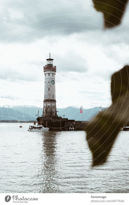 Hafeneinfahrt in Lindau bodensee Blatt eingerahmt Baum Turm Wolken dramatisch wolkig bewölkt Regenwetter Herbst Sightseeing Besichtigung Tourismus See Wasser