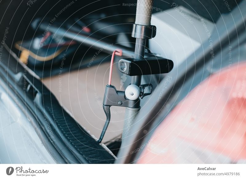 Close up of electric scooter handlebar inside a car open trunk. Transporting modern and ecological vehicle from the shop to the city road. Using new ways of transport. City lifestyle