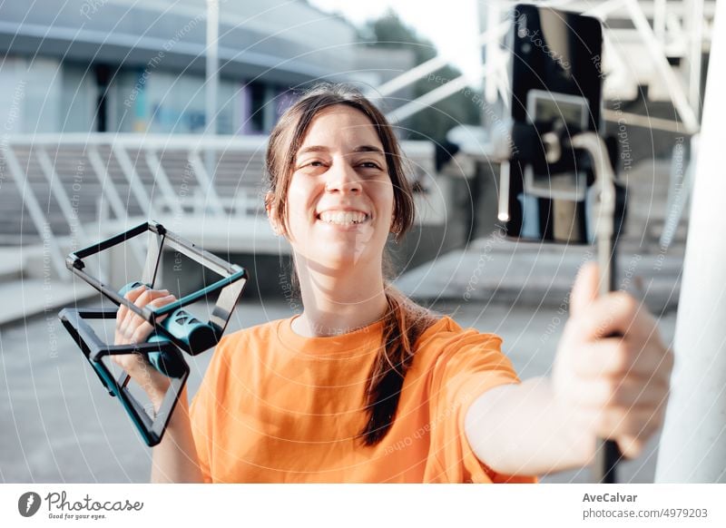 Young woman influencer blogger recording a live streaming on social media,getting ready to start,reading the comments,asking and answering questions holding push ups bar cross training.Healthy life