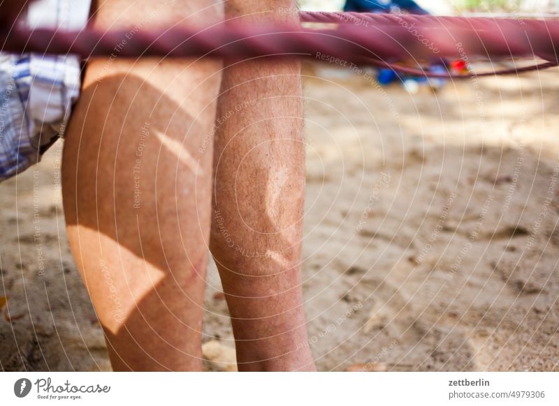 Legs on the playground leg Human being Man Calf Sit Playground Colour photo Exterior shot Summer Sand digging site dig box game Pants