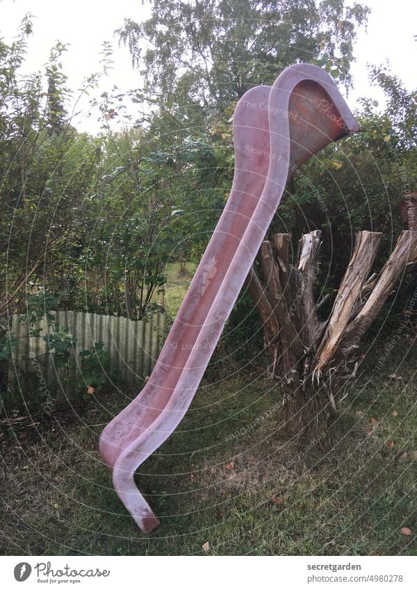 strange | off through the hedge Slide Strange Playground Garden Red Green turned off Broken makeshift Playing Exterior shot Infancy Colour photo Deserted