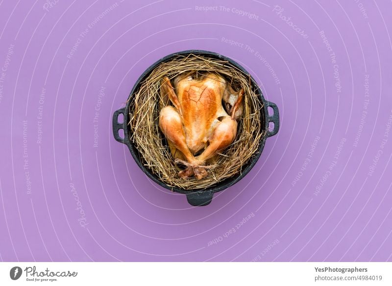 Chicken baked in the hay in an iron cast pot, top view on a purple table. above autumn background bird brown chicken christmas color cooked cuisine delicacy