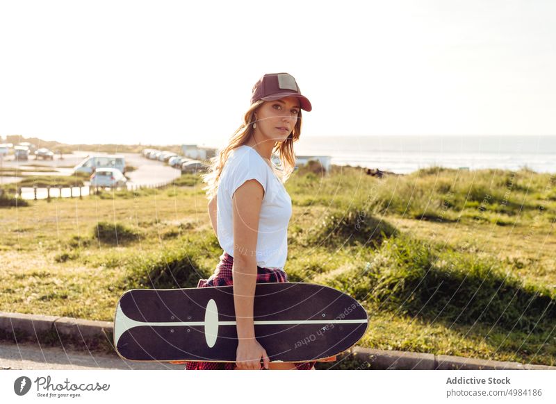 Skater looking away outdoors while holding skateboard woman fashion skater one caucasian skateboarder lifestyle cool girl urban street skateboarding leisure