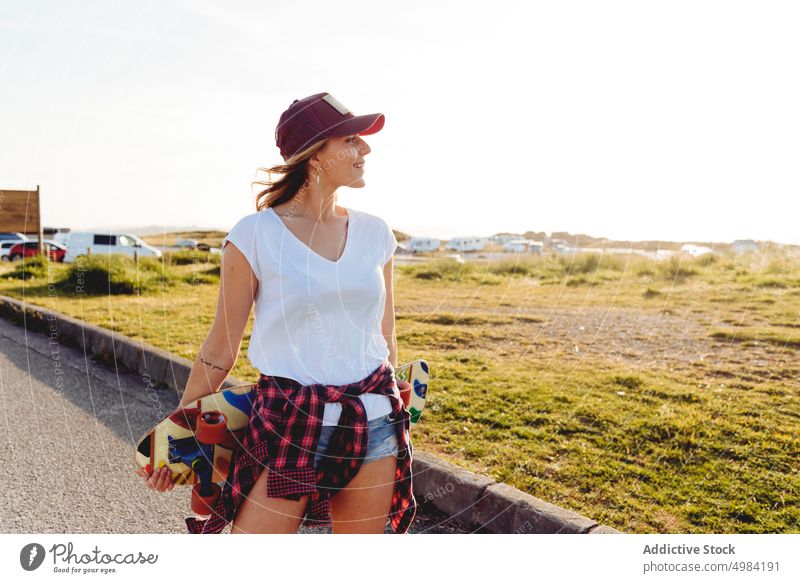 Skater looking away outdoors while holding skateboard woman fashion skater one caucasian skateboarder lifestyle cool girl urban street skateboarding leisure