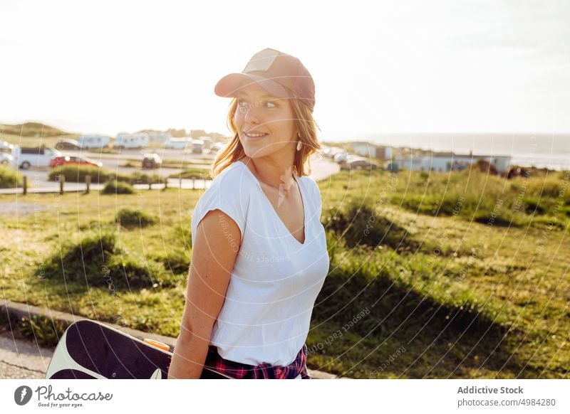 Skater looking away outdoors while holding skateboard woman fashion skater one caucasian skateboarder lifestyle cool girl urban street skateboarding leisure