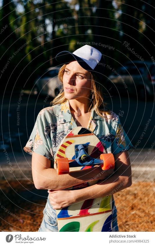 Skater looking away outdoors while holding skateboard woman fashion skater one caucasian skateboarder lifestyle cool girl urban street skateboarding leisure