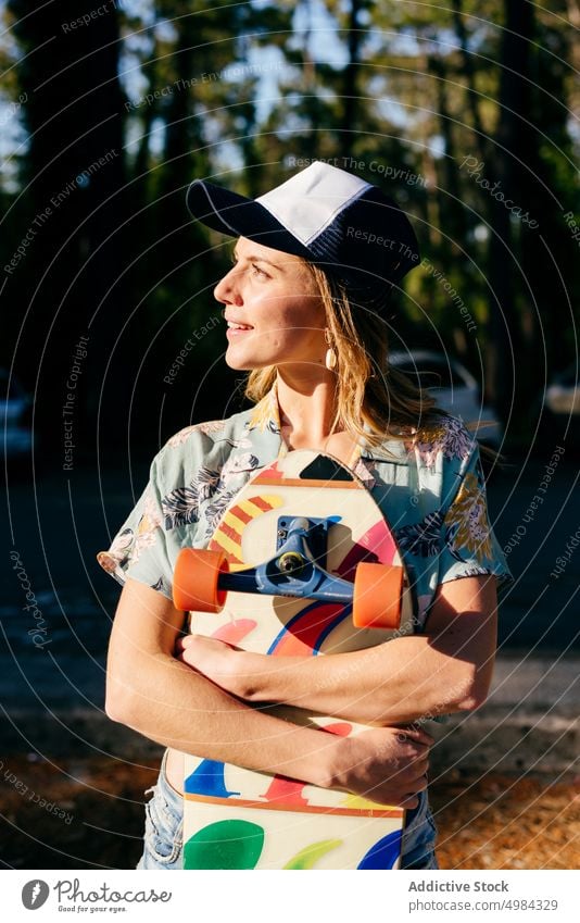 Skater looking away outdoors while holding skateboard woman fashion skater one caucasian skateboarder lifestyle cool girl urban street skateboarding leisure