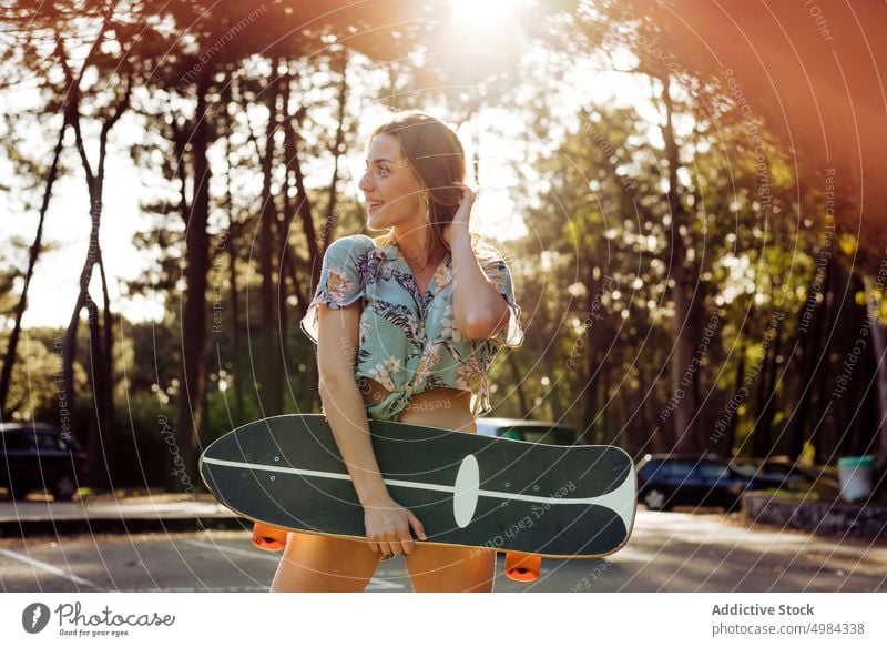 Skater looking away outdoors while holding skateboard woman fashion skater one caucasian skateboarder lifestyle cool girl urban street skateboarding leisure