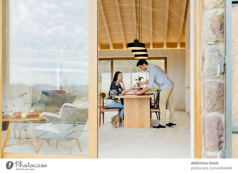 Happy couple dinning at table in kitchen happy hispanic eating plate glass wine smiling woman young attractive cheerful beverage dinner drink meal appetizing