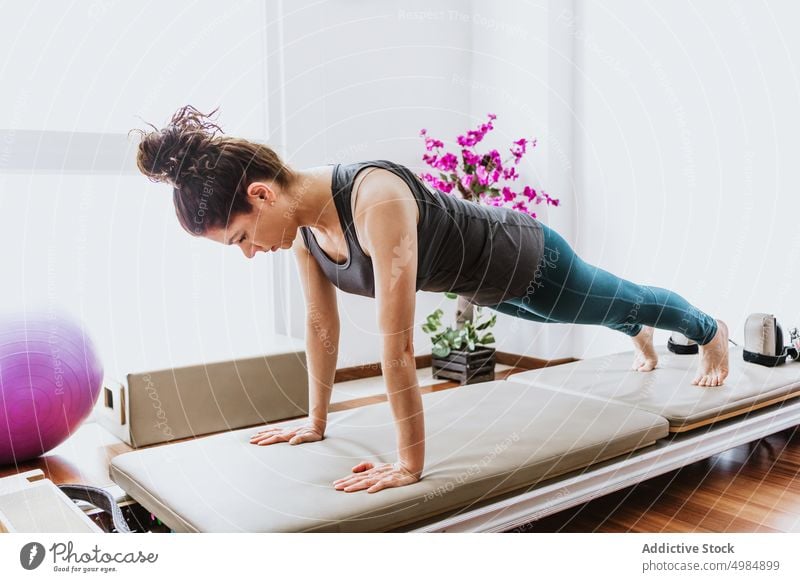 Concentrated young female performing Phalakasana yoga pose in studio woman phalakasana plank wellbeing concentrate healthy balance stamina pilates vitality fit