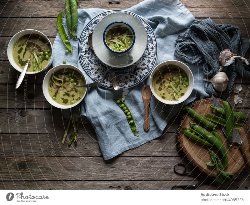 Composition of soup bowls and pea pods composition rustic green gourmet natural cooking eating vegetable served view vegan organic coconut cream design layout