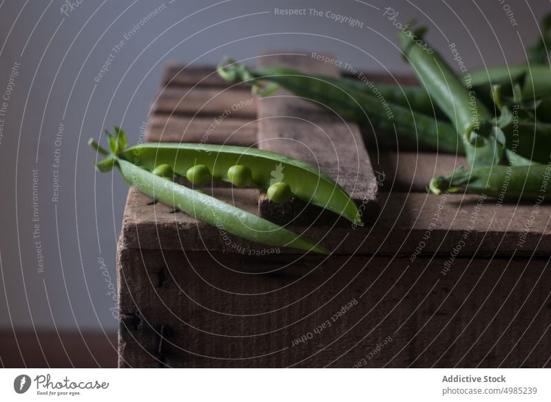 Closeup of pea pod on wood green fresh vitamin food vegetable organic open plant legume nutrition row seed raw harvest vegetarian ingredient grain health vegan