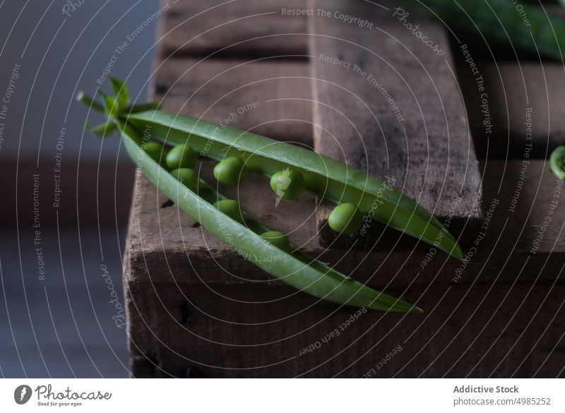 Closeup of pea pod on wood green fresh vitamin food vegetable organic open plant legume nutrition row seed raw harvest vegetarian ingredient grain health vegan