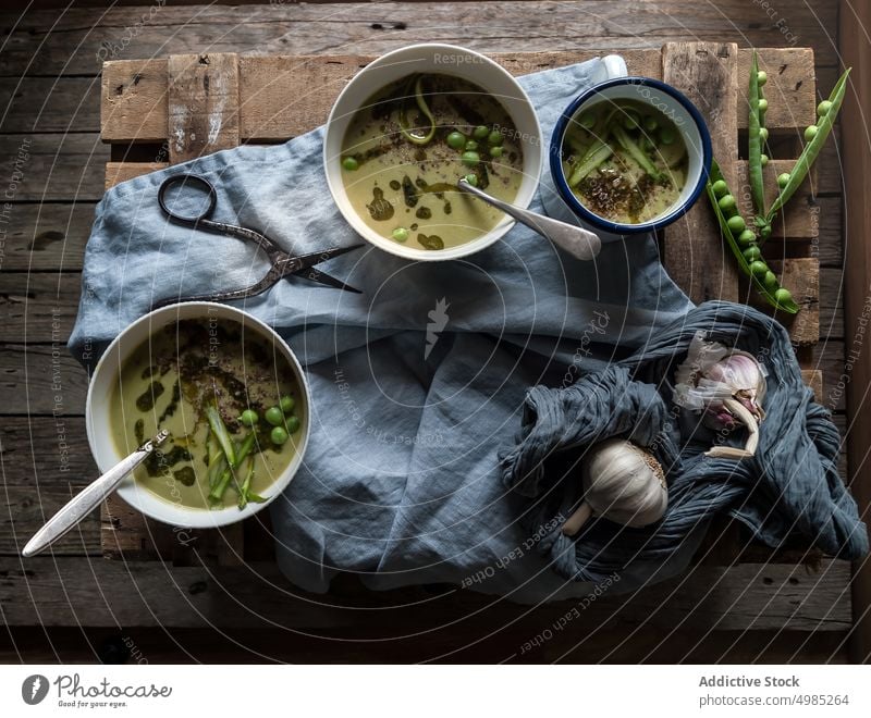 Composition of soup bowls and pea pods composition rustic green gourmet natural cooking eating vegetable served view vegan organic coconut cream design layout