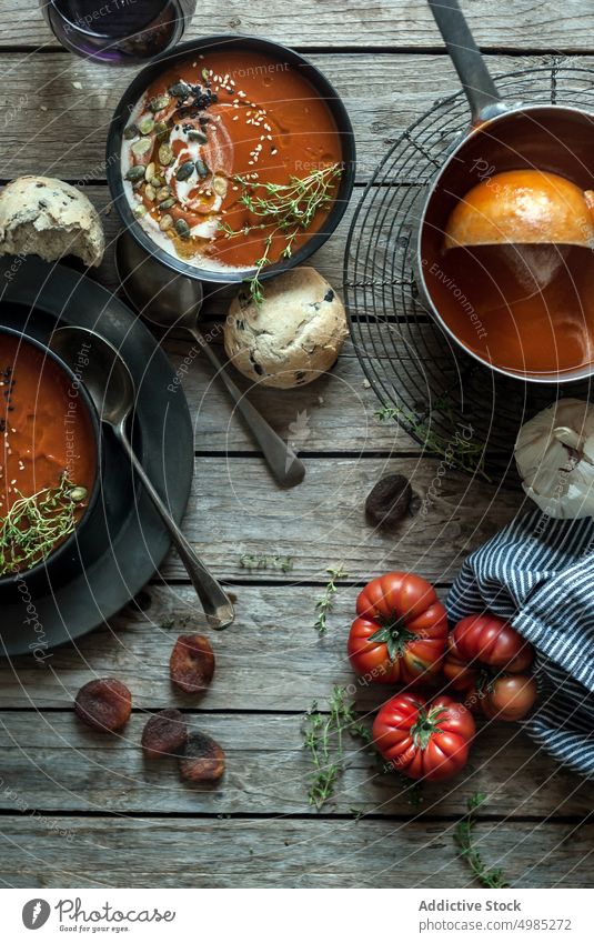 Served soup in bowls on table with vegetable cream tomato served layout seeds apricots wood dried delicious meal bread nutrition buns traditional cutlery