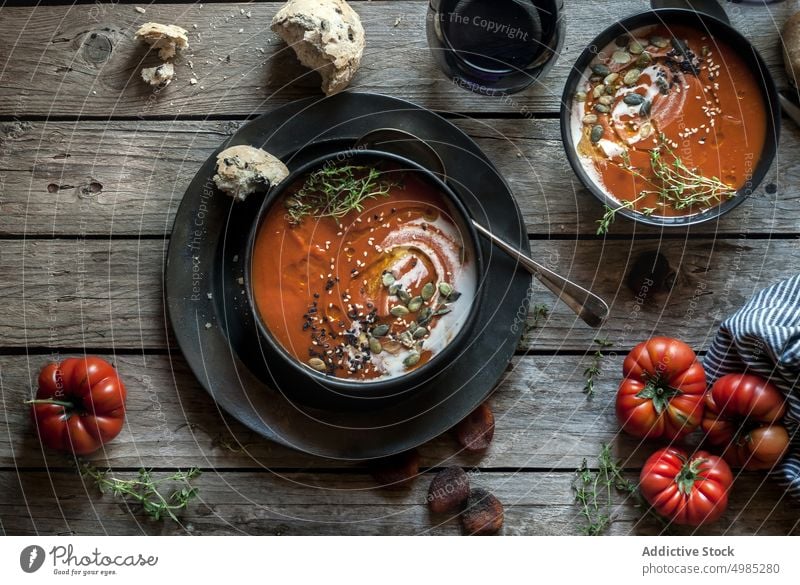 Served soup in bowls on table with vegetable cream tomato served layout seeds apricots wood dried delicious meal bread nutrition buns traditional cutlery