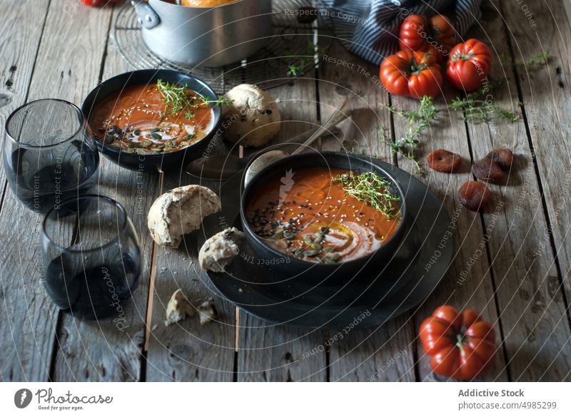 Creamy tomato soup with dried apricots cream served seeds organic buns delicious vegan garnish bread gourmet dish dinner fresh food bowl nutrition vitamin