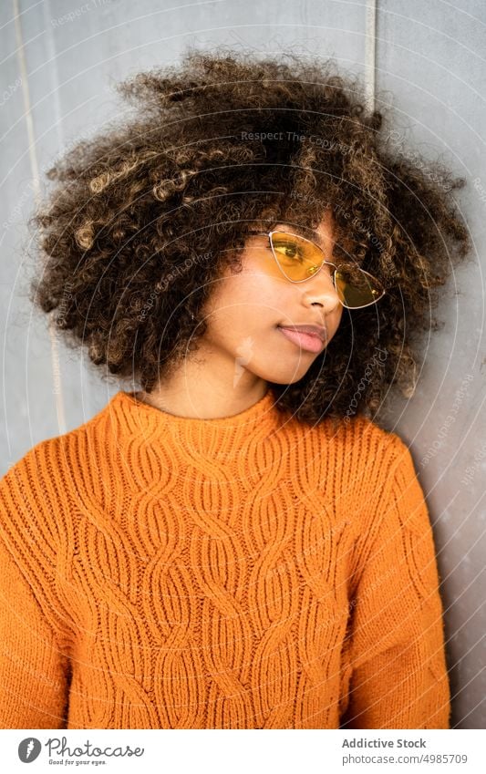 Trendy black woman in bright sweater on street colorful street style ethnic african american modern cool slim sunglasses charming hairstyle afro model trendy