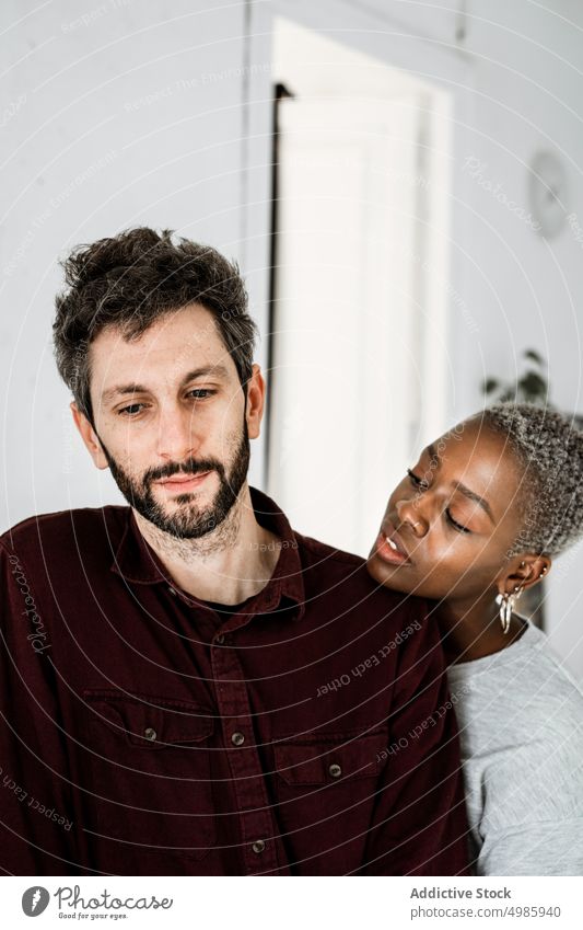 Tender multiethnic couple embracing at home love hug embrace cuddle relationship casual smile together romantic affection african american apartment black