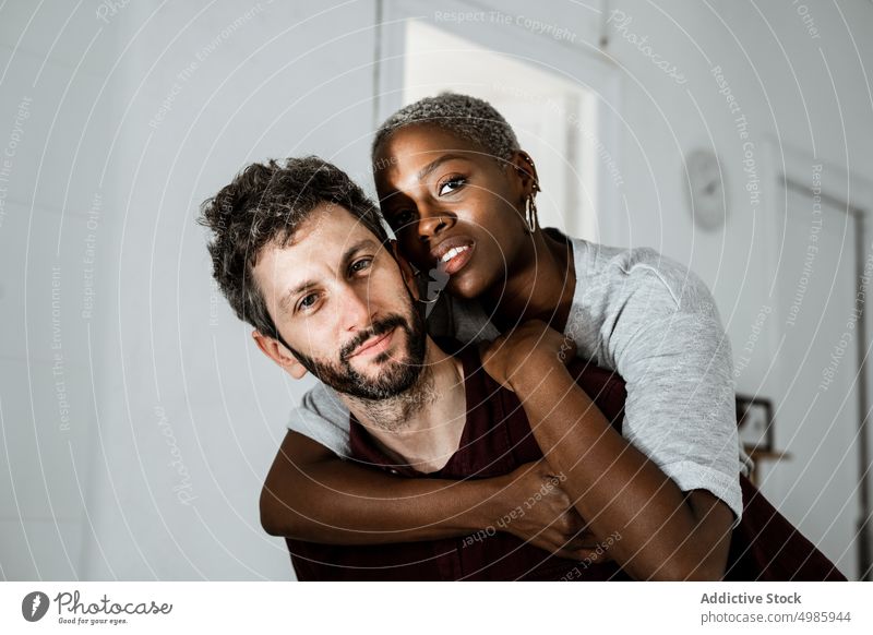 Tender multiethnic couple embracing at home love hug embrace cuddle relationship casual smile together romantic affection african american apartment black