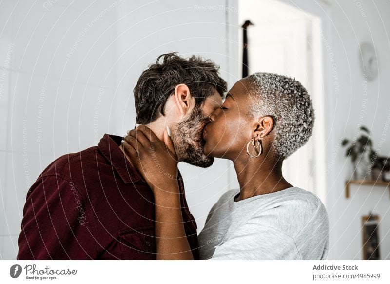 Happy couple cuddling in modern room love hug home embrace cuddle relationship smile laugh enjoy casual together romantic affection multiethnic african american