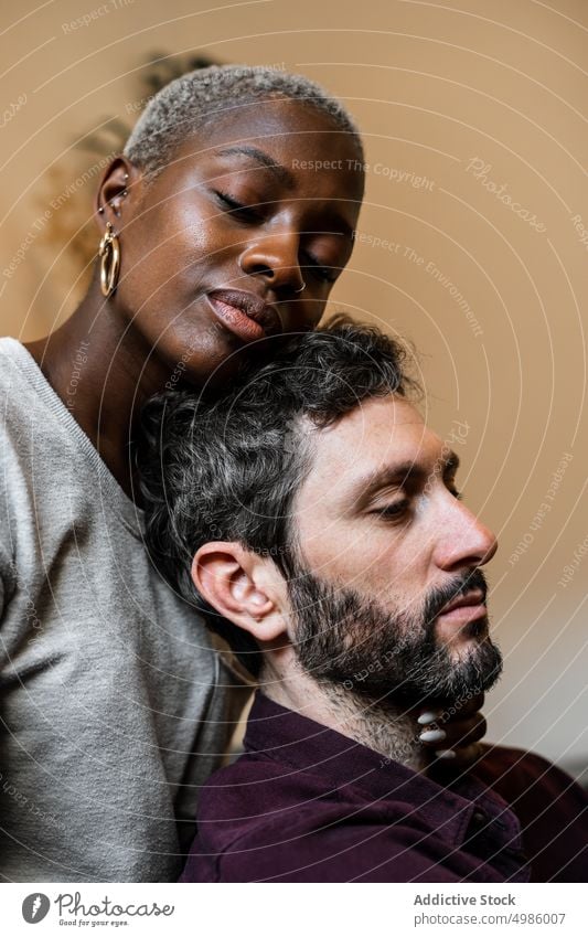 Young multiethnic couple resting on sofa cuddle couch asleep harmony calm home love relax living room bonding relationship hug leisure embrace together romantic